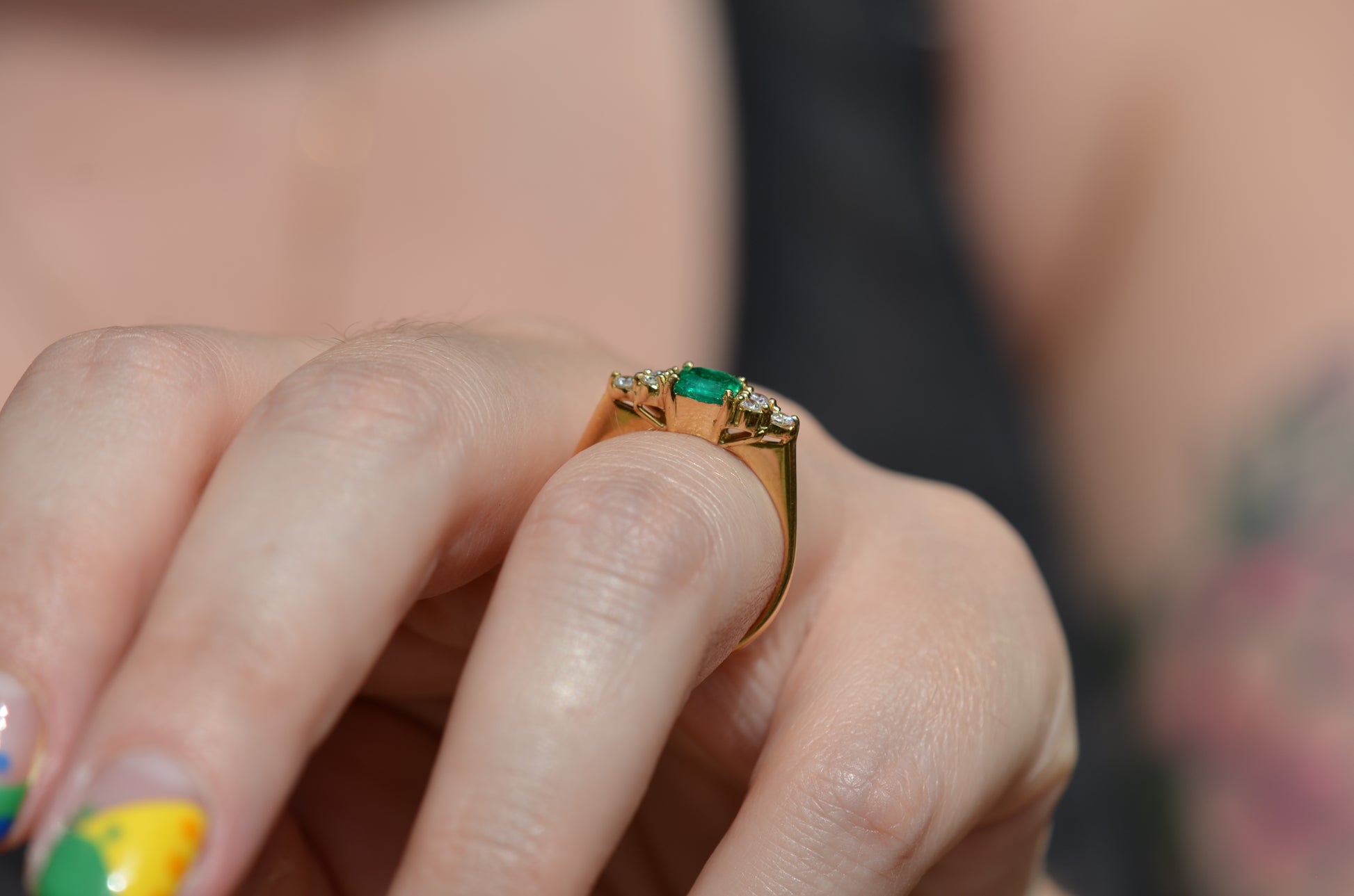 Medium-close photo of the vintage ring on the hand of a Caucasian model's left ring finger in order to show scale when worn. View is highlighting the gallery of the ring and the rise off the finger.